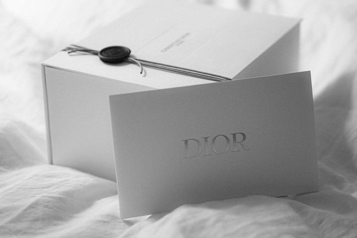 Dior gift box with a card on white fabric