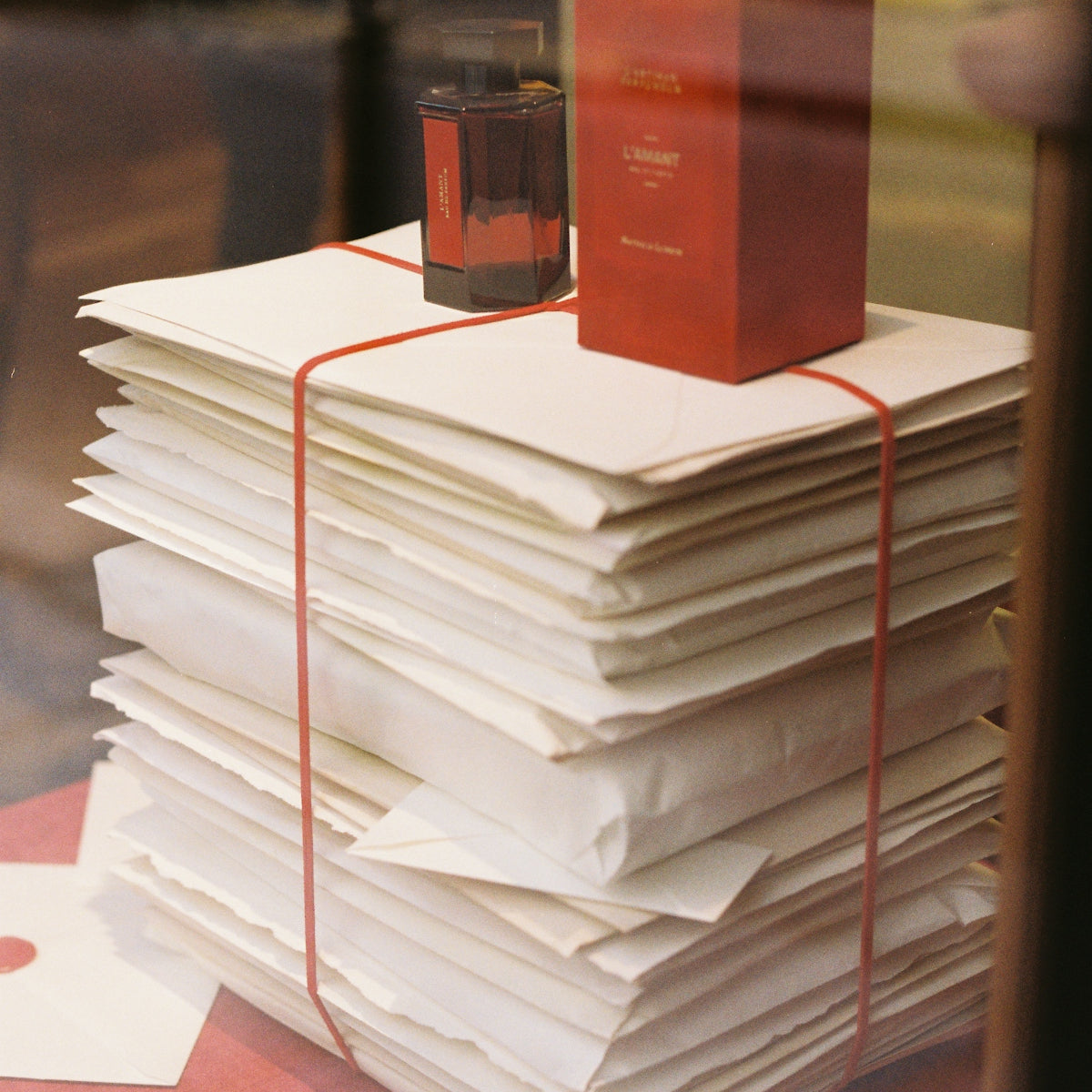 Stack of papers with perfume bottle and box