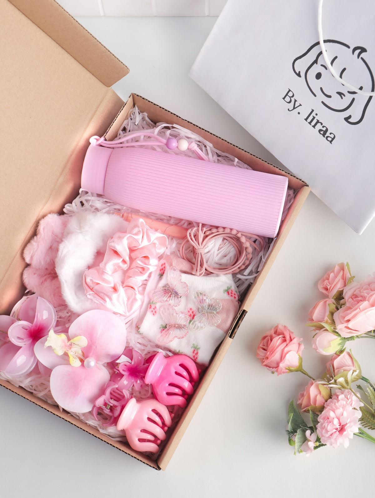 Pink gift box filled with beauty and hair accessories.